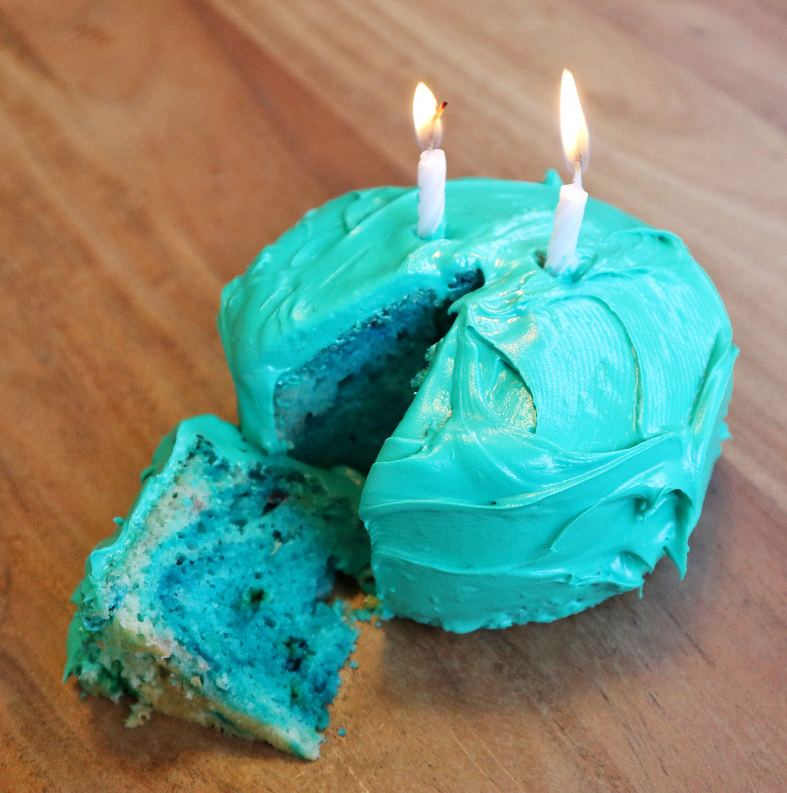 An image of a cake frosted in Truveta colors with two candles.